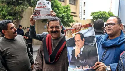  ?? AFP ?? egyptians pose for a picture with a newspaper front page and a poster of President Abdel Fattah el Sisi outside a school in the city of Alexandria on Saturday. —