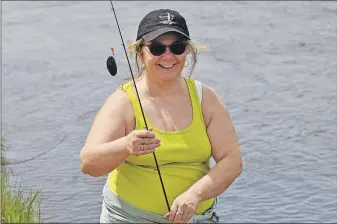  ?? ASHLEY THOMPSON ?? Sheila Ward of Port Williams happily shows off a freshwater mussel she reeled in during a recent shad-fishing trip in Middleton.