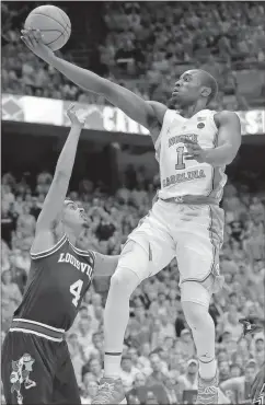  ?? Gerry Broome / The Associated Press ?? North Carolina’s Theo Pinson (right) shoots over Louisville’s Quentin Snider.