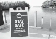  ?? LYNNE SLADKY/AP ?? A sign at the Flamingo boat ramp in Everglades National Park encourages social distancing as the park gradually reopens to the public in phases.