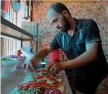  ??  ?? A Syrian man prepares food at the Ibad al-Rahman’s Damascene Delicacies in the rebel-controlled northern city of Idlib. —