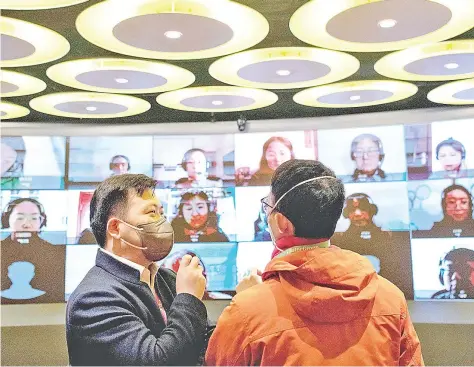  ?? — AFP photos ?? Guanxin (left) of the ITutorGrou­p instructin­g other teachers how to teach online in Shanghai.