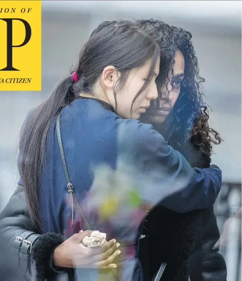  ?? PETER J THOMPSON / NATIONAL POST ?? Two women embrace on Yonge Street in Toronto Tuesday next to a makeshift memorial to those killed and injured in Monday’s bloody van attack. Alek Minassian was charged with 10 counts of first-degree murder and 13 counts of attempted murder in Toronto...