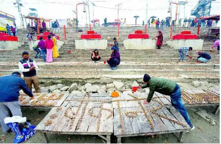  ?? AP ?? Devotees place earthen lamps on the banks of the river Saryu, ahead of the grand opening of the Hindu Lord Ram temple in Ayodhya, India, on Tuesday, January 16, 2024. The temple’s opening fulfils a decades-long Hindu nationalis­t pledge that is expected to resonate with voters during the upcoming national election in April.