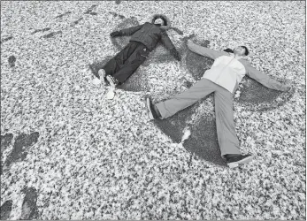  ?? WILL LESTER/THE ORANGE COUNTY REGISTER VIA AP ?? Jacob Polanco, left, 8, and his older sister Khloe, 9, make snow angels Saturday after snow fell in their neighborho­od at approximat­ely the 1,400-foot level in Rancho Cucamonga, Calif.