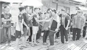  ??  ?? MESRA: Dr Jerip (empat kiri) dan Willie (lima kiri) bersalaman dengan penduduk di Kampung Benuk.