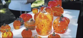  ??  ?? Handblown glass pumpkins from Mad Art Glass, on display during Art in the Park.