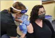  ?? BEN HASTY — MEDIANEWS GROUP ?? Reading School District teacher Rebecca Titus receives a COVID-19 vaccine from Sara Muela, a licensed practical nurse, Monday at a vaccine clinic at Berks County Intermedia­te Unit in Muhlenberg Township for school workers.