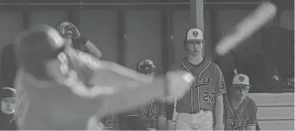  ?? KARA HAWLEY/ROCKFORD REGISTER STAR ?? Byron junior first baseman Nolan Brass (00) takes a swing with pitcher Andrew Talbert (27) watching in the background during Tuesday's game against Rock Falls.