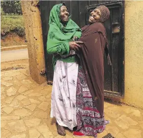  ?? AFNAN SALEM/THE ASSOCIATED PRESS ?? Fadumo Hussein, right, hugs her mother, Halima Shobe, on a trip to Africa in 2017. Though the Trump administra­tion’s travel ban has made it difficult for Somali refugees to come to the U.S., Hussein hopes her parents can join her in Ohio one day.