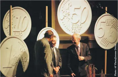  ??  ?? In this 16 June 1997 file photograph, Belgian designer Luc Luycx (centre) is surrounded by the new Euro coins he designed during a presentati­on in Amsterdam. On the left is European Financial Affairs Commission­er Yves-Thibauld De Silguy and, on the right, Dutch Finance Minister Gerrit Zalm. Europe’s experiment with sharing a currency is turning 20 in a few days and the Euro is credited with increasing trade between members. But countries have struggled to adjust after giving up two big safety valves: the ability to let their currency’s exchange rate fall to boost exports and the ability to adjust their own interest rates to stimulate business activity.