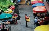  ?? Eric Gay / Associated Press ?? Mariachi musicians play for diners at a restaurant that reopened to 50 percent capacity in May in San Antonio.