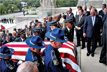  ?? Associated Press ?? ■ Louisiana Governor John Bel Edwards, right, watches as the casket is brought into the Louisiana State Capital building during an honor procession for former Louisiana Gov. Kathleen Babineaux Blanco on Thursday in Baton Rouge, La. Thursday was the first of three days of public events to honor Blanco, the state’s first female governor who died after a years long struggle with cancer.