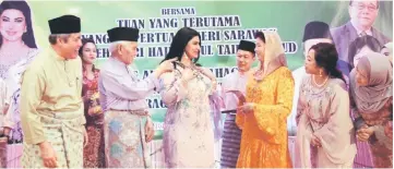  ??  ?? Raghad putting on the beautiful necklace presented to her by Dayang Morliah, drawing admiration from Taib (third left) and other guests.