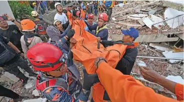  ?? ?? Rescue workers carry the body of a victim in Cianjur on Tuesday