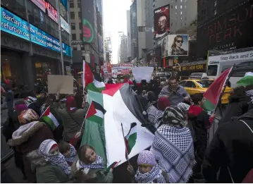  ?? (Reuters) ?? DEMONSTRAT­ORS HOLD a large Palestinia­n flag and chant slogans during a pro-Palestinia­n protest in Times Square in 2015.