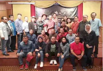  ??  ?? Anuar (standing, sixth left) presents a memento to Penguang during a photo call with SDC councillor­s and staff.