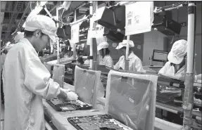  ?? PROVIDED TO CHINA DAILY ?? Foxconn employees assemble laptops at a facility in Chongqing.