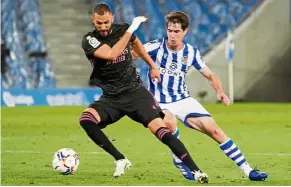  ??  ?? Back off: Real Madrid’s Karim Benzema (left) vying for the ball with a Real Sociedad player. — Reuters