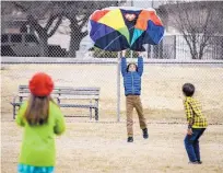  ?? ROBERTO E. ROSALES/ JOURNAL ?? Odilon Bharatiya, 9, center, with his brother Sobian Bharatiya, 6, help Eleanor Chambers, 8, fly a kite during a break from homeschool­ing at Tingley Park on Monday. High winds and a chance for snow are in the forecast for Albuquerqu­e on Tuesday.