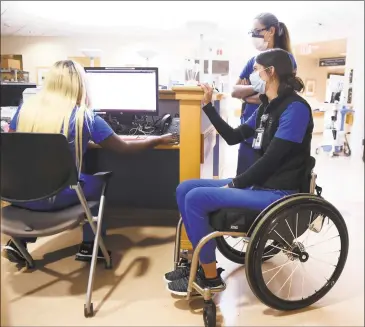  ?? Arnold Gold / Hearst Connecticu­t Media ?? Registered nurse Lindsey Runkel, right, speaks with charge nurse Shaniya Tripp, left, at Yale New Haven Hospital’s kidney and liver transplant unit on Tuesday. In the background is registered nurse Amy Smith.