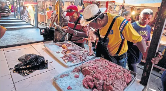  ?? Fernando LLano/ap ?? En un mercado de Maracaibo, un venezolano huele un pedazo de carne para comprobar su estado