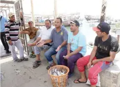  ??  ?? KUWAIT: Fisherman Hasouna Eisa (center) speaks to Kuwait Times at Sharq marina. — Photos by Yasser Al-Zayyat