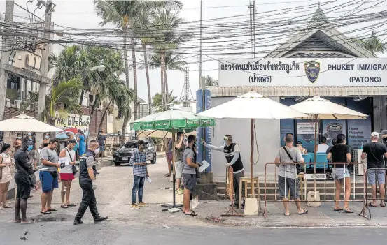  ?? ADAM DEAN/THE NEW YORK TIMES ?? Sem saída. Autoridade­s de imigração de Phuket, na Tailândia, monitoram a temperatur­a de turistas que estão retidos no país e precisam estender seus vistos