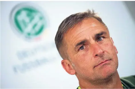 ?? FOTO: DPA ?? U21-Nationaltr­ainer Stefan Kuntz (55) vor dem Logo des Deutschen Fußball-Bundes.