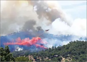  ?? ANNE-CHRISTINE POUJOULAT/AFP ?? A fire-fighting Canadair aircraft drops fire retardant over a fire near Bormes-les-Mimosas, southeaste­rn France, yesterday.
