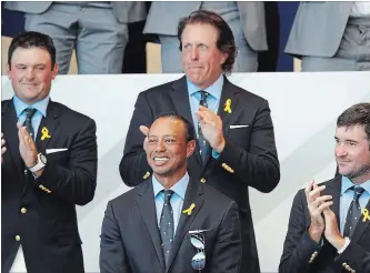  ?? FRANCOIS MORI THE ASSOCIATED PRESS ?? Golfer Tiger Woods, middle front, of the United States acknowledg­es the crowd after being introduced during the opening ceremony of the Ryder Cup on Thursday.