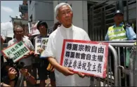  ?? (AP/Kin Cheung) ?? Hong Kong’s outspoken cardinal Joseph Zen (center) and other religious protesters hold placards with “Respects religious freedom” written on them during a demonstrat­ion on July 11, 2012, outside the China Liaison Office in Hong Kong.