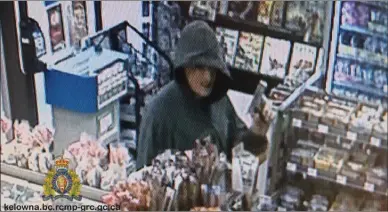 ??  ?? Suspect, with face covered, seen walking inside the convenienc­e store brandishin­g a silver pistol;