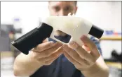  ?? Associated Press ?? Cody Wilson, of Defense Distribute­d, holds a 3D-printed gun in his Texas shop.