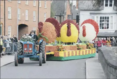  ??  ?? TRACTOR TURBO: A float full of turkeys made of flowers is pulled through the streets of Spalding
