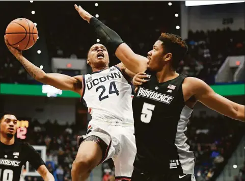  ?? Jessica Hill / Associated Press ?? UConn’s Jordan Hawkins (24) shoots while defended by Providence’s Ed Croswell on Dec. 18 at the XL Center in Hartford.