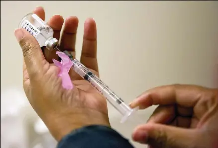  ?? A nurse prepares a flu shot. FILE PHOTO ??