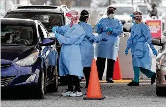  ?? CURTIS COMPTON/ CURTIS. COMPTON@ AJC. COM ?? Elham Roshanraun ( left) and other nurses assist motorists on Wednesday at the Dekalb County Board of Health’s free COVID- 19 testing site at Brandsmart USA in Doraville.
