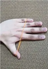  ??  ?? Thumb abduction: Place your palm on a flat surface with a rubber band around the fingers and thumb. Move your thumb as far away from the four fingers as you can and hold the stretch for 10 seconds before relaxing.