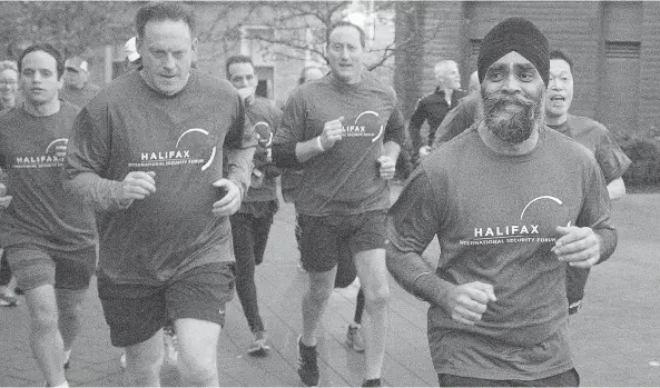  ?? ANDREW VAUGHAN / THE CANADIAN PRESS ?? Canadian Defence Minister Harjit Sajjan, right, is followed by former defence minister Peter MacKay, centre, as he leads a five kilometre run on the third day of the Halifax
Internatio­nal Security Forum in Halifax on Sunday. At the forum, Sajjan...