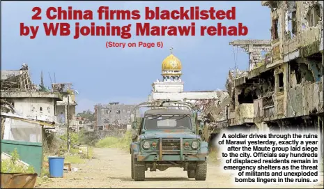  ?? AP ?? A soldier drives through the ruins of Marawi yesterday, exactly a year after the Maute group laid siege to the city. Officials say hundreds of displaced residents remain in emergency shelters as the threat of militants and unexploded bombs lingers in...