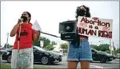  ?? JEFFEREE WOO / TAMPA BAY TIMES VIA AP ?? Chrisley Carpio and Victoria Hinckley speak to protesters during an abortion rights rally on Saturday in Temple Terrace, Fla.