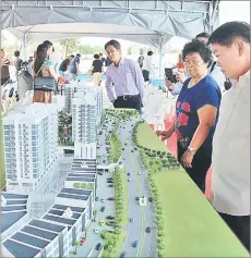  ??  ?? Guests take a closer look at the SK One Garden City model.