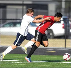  ?? NWA Democrat-Gazette/ANTHONY REYES • @NWATONYR ?? Springdale High’s Salvador Gonzalez ball Tuesday in Centerton. (right) races Tanner Travis (17) of Bentonvill­e West for the