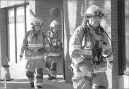  ?? Herald photo by Melissa Villeneuve ?? Lethbridge firefighte­rs Andy Houthuis, left, Steve Sharp and Drew Ginther complete their laps for the seventh annual Lethbridge Memorial 9/11 Stair Climb at Lethbridge Centre tower Sunday. In top photo, Grande Cache firefighte­r Aandrea Gardiner smiles...