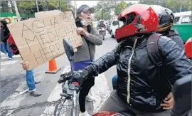  ??  ?? ANOTHER volunteer in Mexico City solicits donations of tools, water and medicine for quake victims. Others handed out meals to dust-covered rescuers.