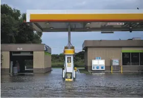  ?? Brendan Smialowski / AFP / Getty Images ?? Hurricane Harvey caused all sorts of flooding in Houston, including this gas station, but it’s hard to tell how much it has affected gas prices.