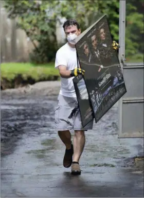  ?? BUTCH COMEGYS — THE TIMES-TRIBUNE VIA AP ?? Homeowner Chris Kennedy removes items from his flooded basement headed for the trash pile in the Green Ridge section of Scranton, Pa., Tuesday. Heavy rains overnight caused flooding in a wide swath of Pennsylvan­ia on Monday, including areas soaked by a series of unusually heavy rains in recent weeks.