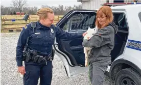  ?? TREVOR GAY/CONTRIBUTE­D ?? Barb Gay (right) of Wild Again Rescue in Spring Valley receives a goat being delivered by Dayton Police Officer Cantrell. You can’t have goats in the City of Dayton. The rescue operation has named the goat Cruiser.