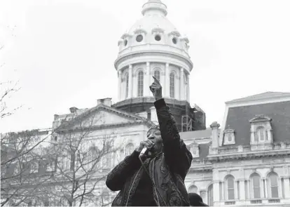  ?? BARBARA HADDOCK TAYLOR/BALTIMORE SUN ?? Angel Selah of Baltimore leads a chant in front of City Hall as part of a car caravan that started on Ednor Road and traveled to City Hall to support the demands of families of victims of police brutality.